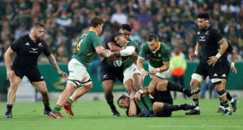 South Africa's fullback Damian Willemse C is tackled by New Zealand's wing Caleb Clarke bottom and New Zealand's hooker Samisoni Taukei'aho 3rd L during the Rugby Championship international rugby match between South Africa and New Zealand at the Mbombela Stadium in Mbombela on August 6, 2022..  By PHILL MAGAKOE AFP