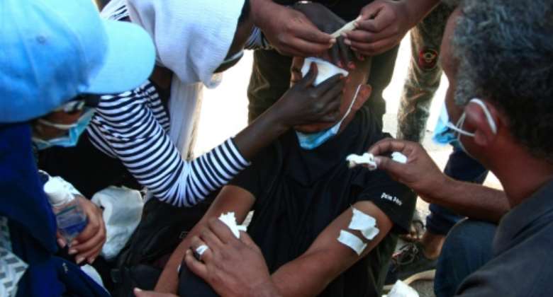 Sudanese protesters treat a young man's wounds at the scene of confrontations with security forces, in the capital Khartoum on December 25, 2021, during a demonstration demanding civilian rule.  By - AFPFile