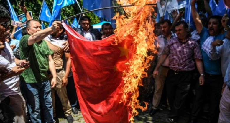 Supporters of the mostly Muslim Uyghur minority and Turkish nationalists burn a Chinese flag during a protest.  By OZAN KOSE AFPFile