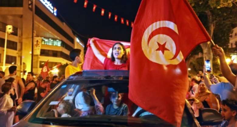 Supporters of Tunisia's President Kais Saied rejoice on Habib Bourguiba Avenue in the capital Tunis after the projected outcome of a constitutional referendum was announced.  By Anis MILI AFP
