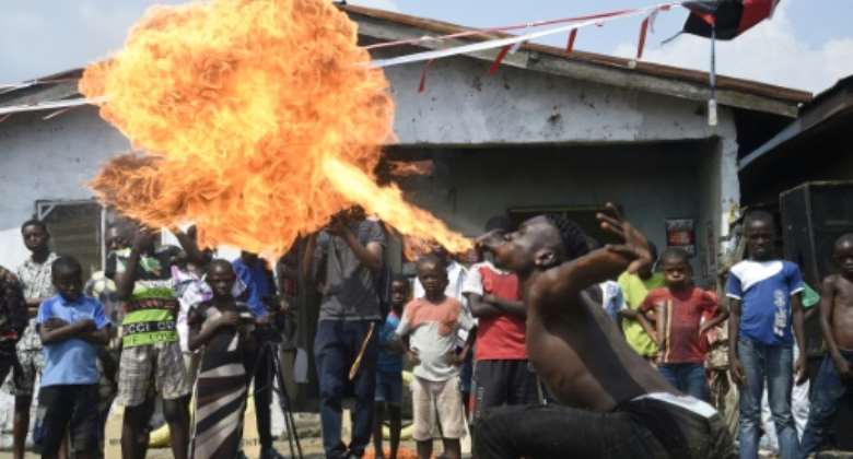 The 'Slum Party' included dance and fire breathing stunts.  By PIUS UTOMI EKPEI (AFP)