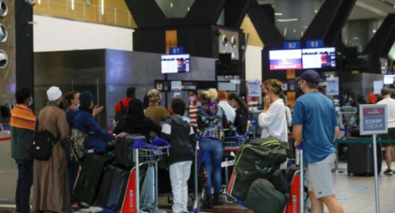 Travellers queue at check-in counters at Johannesburg international airport on Saturday after several countries banned flights from South Africa following the discovery of the new Covid-19 variant Omicron.  By Phill Magakoe (AFP)