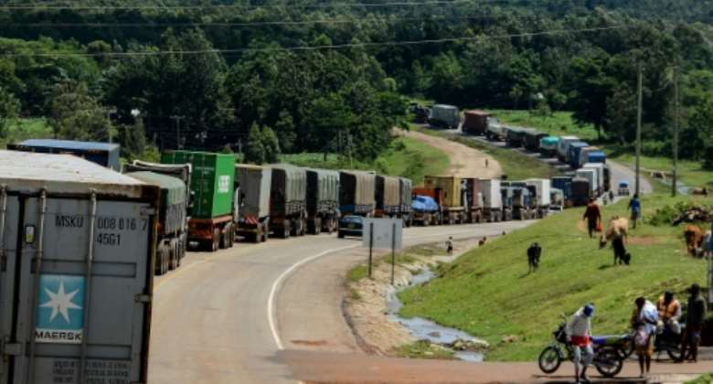 Trucks wait to enter Uganda where one city has prohibited drivers from permitting 'even their wives' in the front cabin of lorries.  By Brian ONGORO AFP
