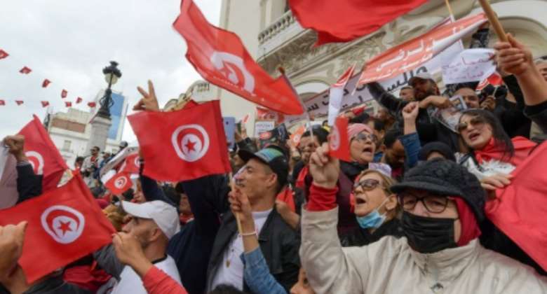 Tunisian demonstrators chant slogans and wave their country's national flag in support of President Kais Saied, in the capital Tunis.  By FETHI BELAID AFP