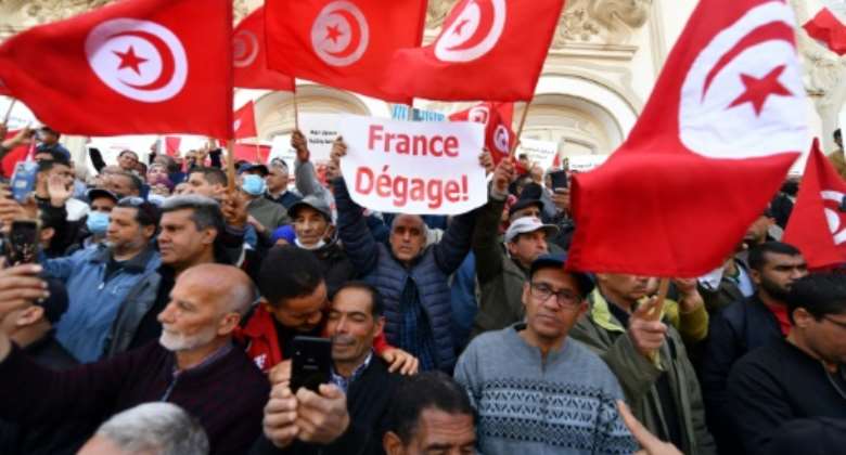 Tunisians raise national flags as they take to the streets of the capital Tunis to protest against their president on April 10, 2022.  By FETHI BELAID AFPFile