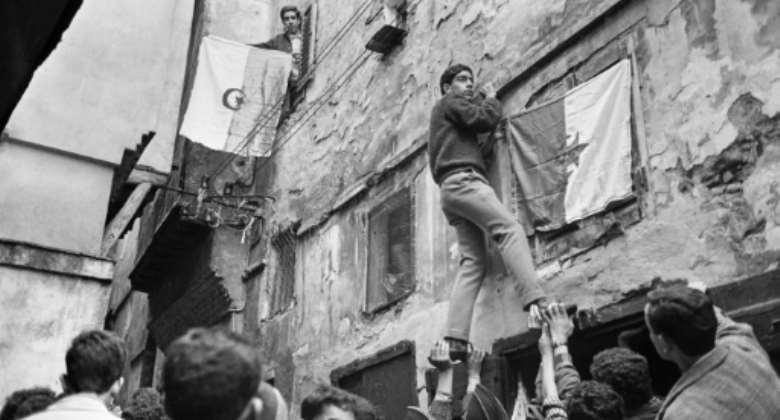 Young Algerians hang their country's national flag on buildings in the capital on July 6, 1962, a day after the North African country won its independence from France following an eight-year war.  By - AFPFile