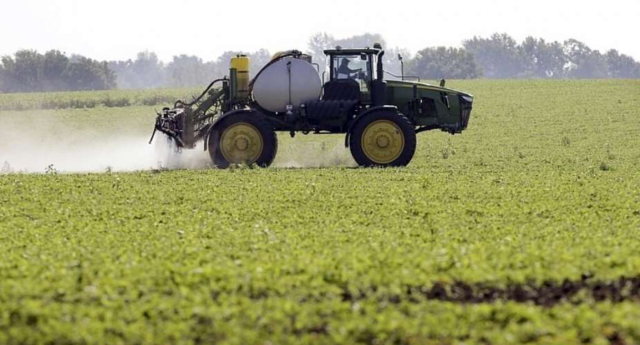 This file photo shows a tractor spraying pesticides on a soybean field in the US on July 11, 2013. -  Charlie Neibergall, AP