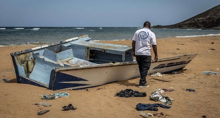This file photo shows a member of the International Organization for Migration (IOM) inspecting the abandoned wreckage of a boat that capsized while attempting to transport migrants to Yemen along the so-called Eastern Route at Gehere beach, near Obock, Djibouti, on April 12, 2026. -  Luis Tato, AFP