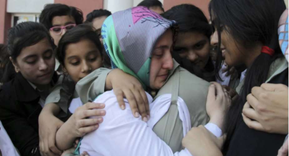 Pakistani students at a PakTurk International school comfort a Turkish teacher facing deportation in Lahore in late 2016. K.M. ChaudaryAP