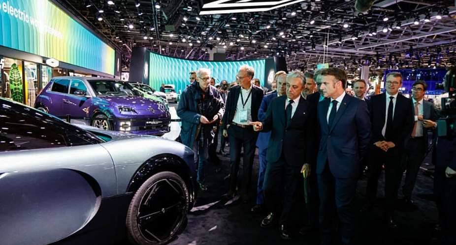 French President Emmanuel Macron speaks with Renault general manager Luca De Meo at the 2024 Paris Motor Show. - via REUTERS - LUDOVIC MARIN