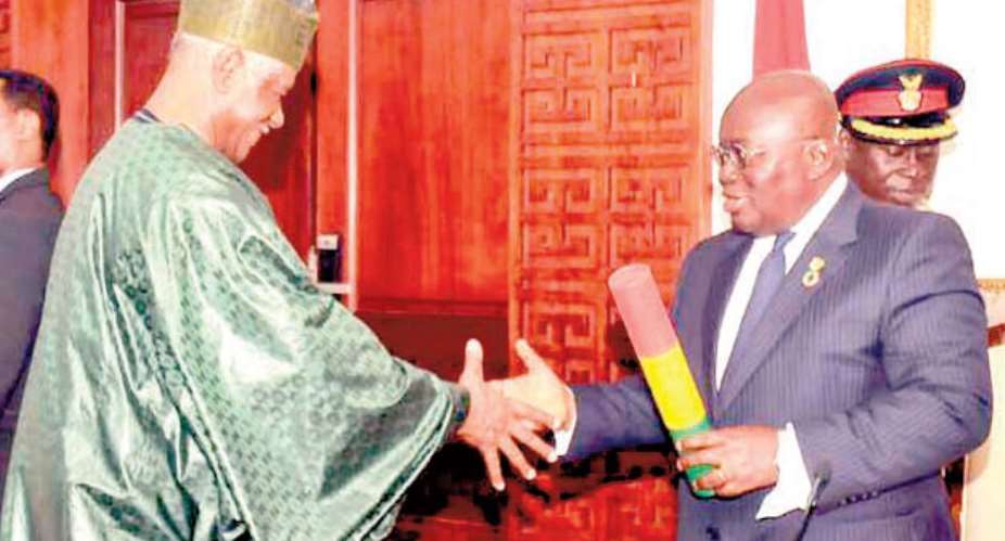 President Akufo-Addo presenting the instrument of office to Ahmed Ramadan at the Flagstaff House on Accra Wednesday