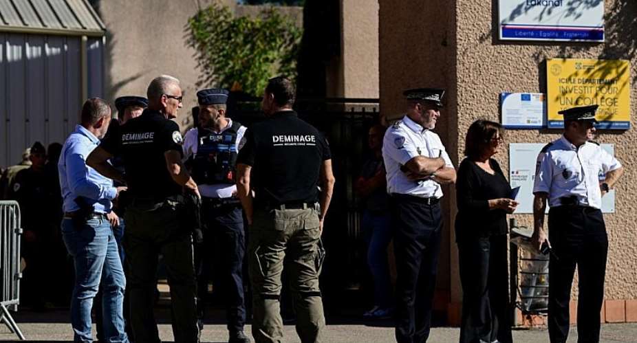 Police officers stand outside the Joseph-Lakanal Middle School after a teenager shot a headmaster and teacher on October 12, 2026. -  Miguel Medina, AFP
