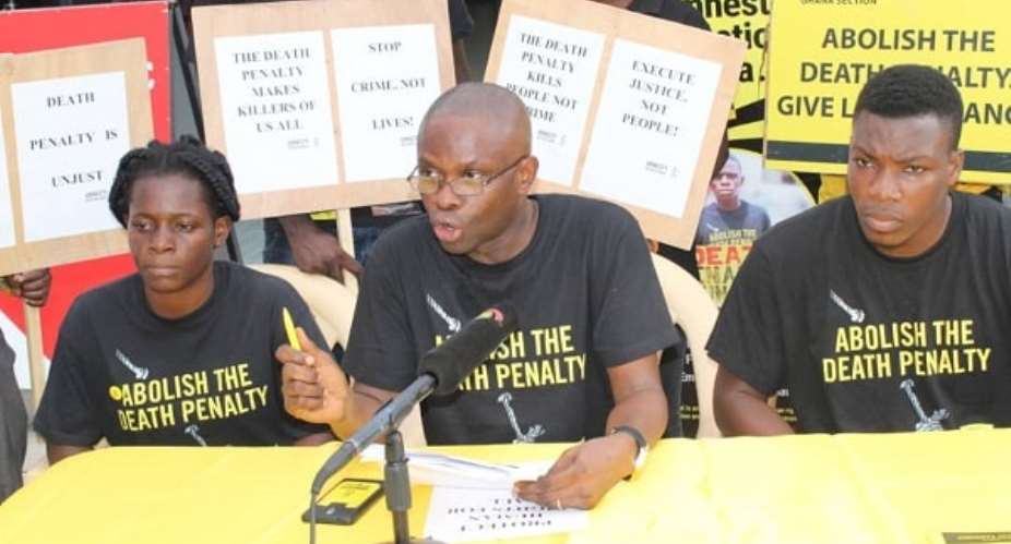 Mr Samuel Komla Agbotsey middle, Campaigns and Fundraising Co-ordinator for Amnesty International, Ghana, addressing the public on the impact of the death penalty on children. With him are Paul Gozo right and Gloria Emeka, both members of AI Ghana . Picture: Patrick Dickson