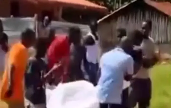One of the deceased being carried into a waiting taxi
