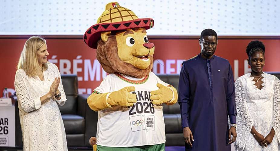 Aya, the official mascot of the 2026 Dakar Youth Olympic Games, flanked by the President of the International Olympic Committee (on the left) and the President of the Republic of Senegal, Bassirou Diomaye Faye. Standing beside her is Ndye Mariama Diop, who won the design competition. - AFP - PATRICK MEINHARDT
