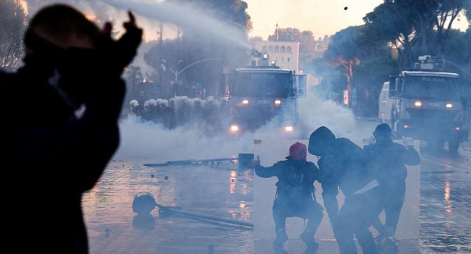 Protesters take cover as police use a water cannon amid an anti-government protest by students in Tirana, Albania, October 14, 2026 -  Florion Goga, Reuters