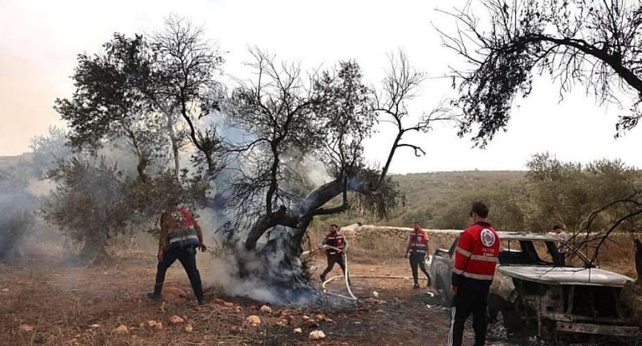 Palestinian volunteers douse an olive tree set on fire by Israeli settlers, near the village of Turmus Ayya, north of Ramallah, in the Israeli-occupied West Bank on October 16, 2026. -  Ahmad Gharabli, AFP