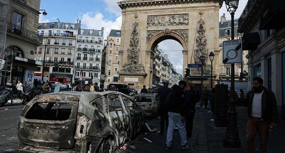 People inspect a destroyed vehicle, the day after clashes during a national day of demonstrations against the cost of living and rising fuel prices, in Paris, France, October 18, 2026. -  Stephanie Lecocq, Reuters