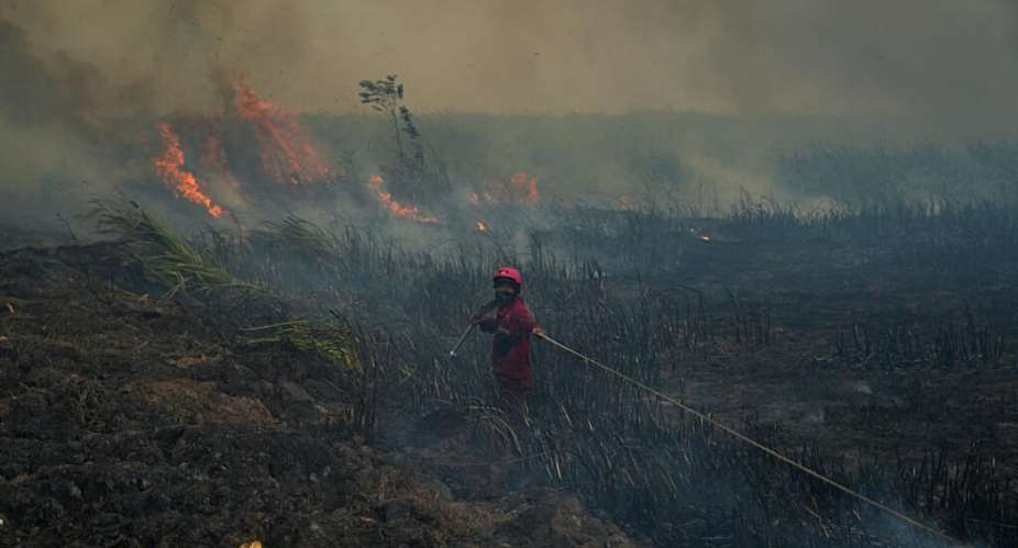A firefighter with the Manggala Agni, Indonesias national fire control bridgade, pulls a hose while extinguishing wildfires near a residential area in Ogan Ilir, South Sumatra, Indonesia, September 25, 2026. -  Abriansyah Liberto, Reuters