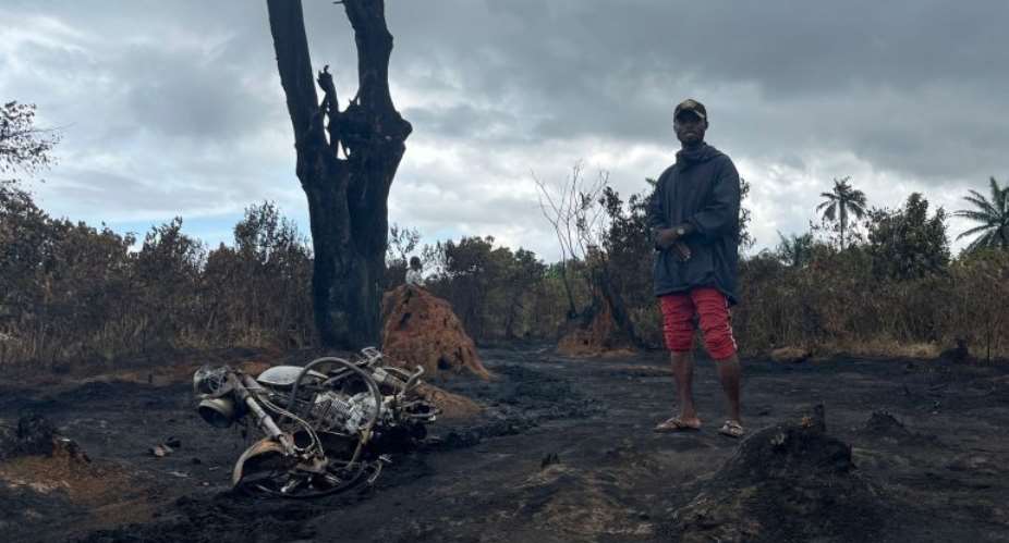 A man stands at the site of the illegal refinery explosion in Emohua, Niger Delta, Nigeria AP Photo