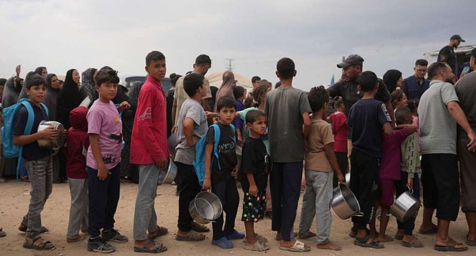 Palestinians line up to receive food donated by the World Food Programme at a displacement camp in Deir al-Balah, in central Gaza, on October 18, 2026. -   Abdel Kareem Hana, AP