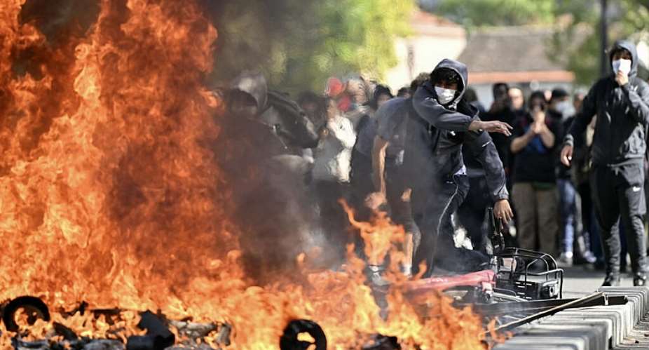 A sixth-form student adds fuel to a burning barrier during a protest outside Le Corbusier Lyce in Aubervilliers, north of Paris, on 1 October 2026. - AFP - LOU BENOIST