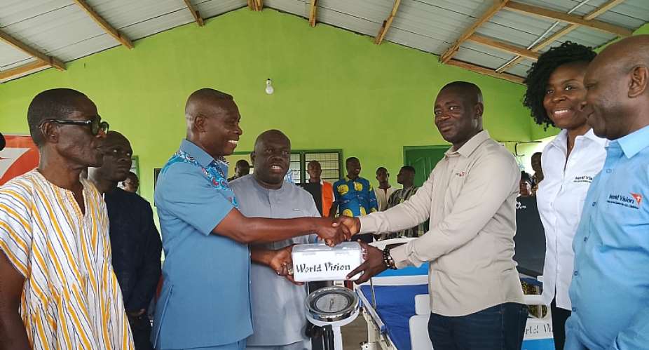 Mr. Joshua Roland Baidoo National Director World Vision Ghana presenting to DCE of Agortime Ziope District Hon. Alfred Dikro