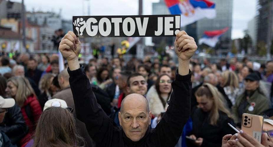 A supporter of the Student List holds a sign reading He is Finished, referring to Serbias former president Aleksandar Vucic during a campaign rally in Belgrade, 22 October. - REUTERS - Uros Arsic