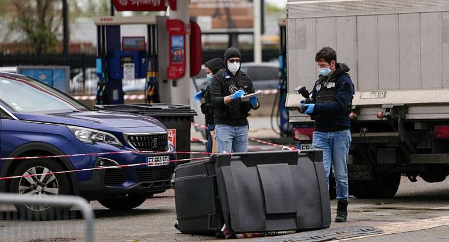 Police officers look at evidences on a site of a petrol station where a man opened fire from his car, killing one person and injuring four others according to police sources, in Trappes, Paris suburb on October 23, 2026. -  Dimitar Dilkoff, AFP