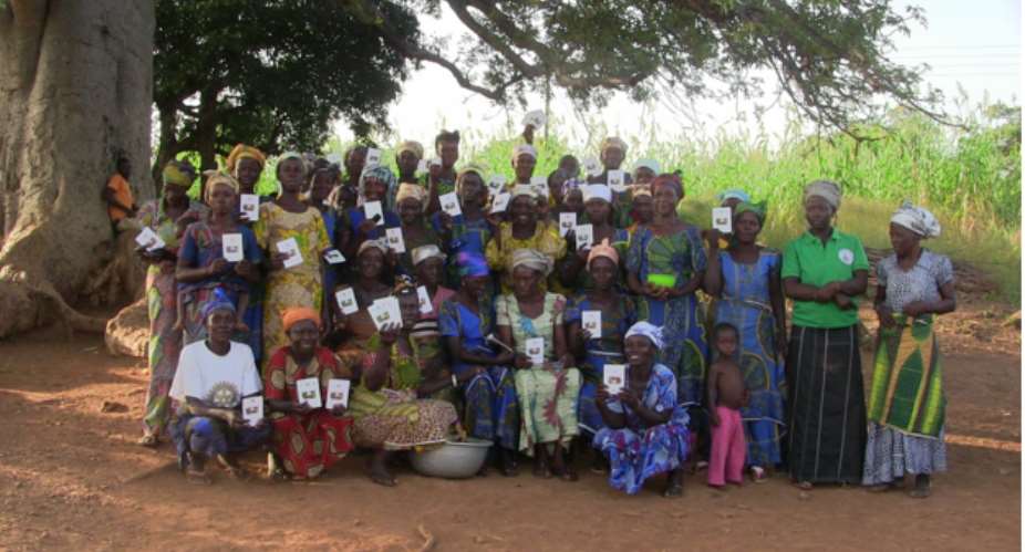 Some members of the Village Savings and Loan Association holding their saving cards in group picture