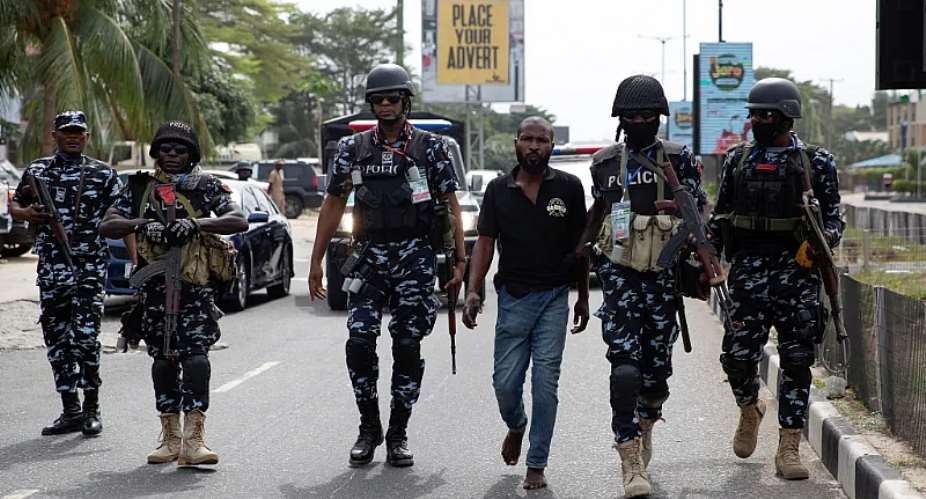 Police officers detain a man in Lagos, Nigeria, on February 25, 2023. Police arrested journalist Saint Mienpamo Onitsha at gunpoint in Bayelsa State on October 10, 2023, over a report he published about the Presidential Amnesty Program. ReutersJames Oatway