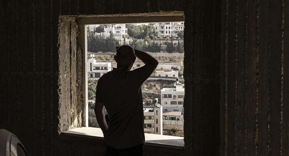 A Palestinian man looks on at empty homes after the Israeli army forced people to evacuate the Ein Deir Baha neighborhood in the occupied West Bank city of Hebron. -  John Wessels, AFP