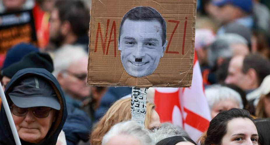 A person holds a placard against Rassemblement Nationals president Jordan Bardella, as people attend a demonstration against racism, fascism, and imperialism as the French far-right Rassemblement National (National Rally, RN) party holds its congress in Orleans, France, 24 October 2026. - REUTERS - Stephanie Lecocq