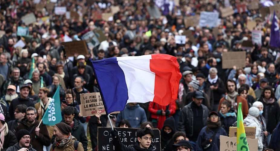 A protester holds a French national flag during an authorised demonstration organised by labour unions in Paris as part of nationwide protests called by the Yellow Vests movement joined by French high school and university students against the cost of living and rising fuel prices, in France, 24 October 2026. -  Abdul Saboor / Reuters