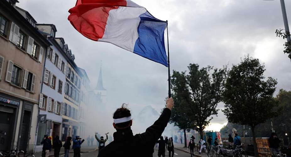 A protester holds a French flag during a demonstration against rising living costs in Strasbourg on October 24, 2026. -  Jean-Francois Badias, AP