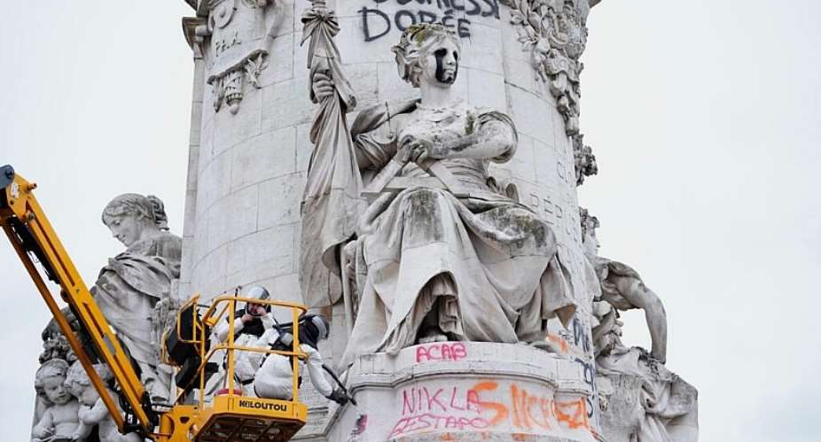 A worker cleans up graffiti after the weekend protests over the cost of living turned into rioting and looting across France, Paris, October 21, 2026. -  Teresa Suarez, AP