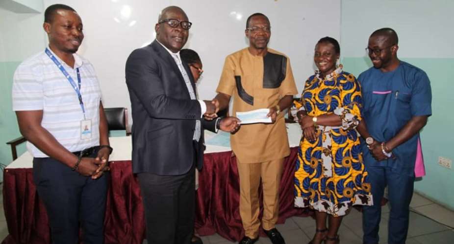 Mr Frank Ebo Brown 2nd left presenting a cheque to Dr. Affail Monney 3rd right