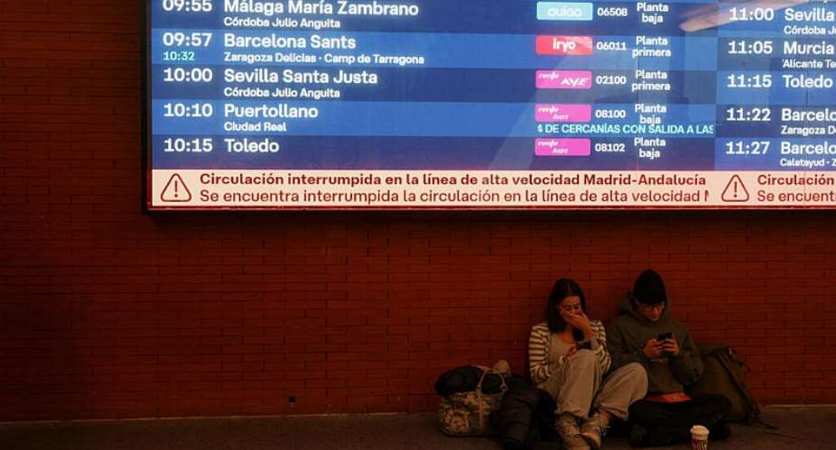 Passengers sit below an information screen reporting the collision between high-speed trains, at Madrids Atocha train station on October 28, 2026. -  Susana Vera, Reuters