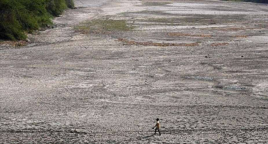 A man walks across the dry bed of the river Yamuna following hot weather in New Delhi, India, 2 May 2022. -  AP - Manish Swarup