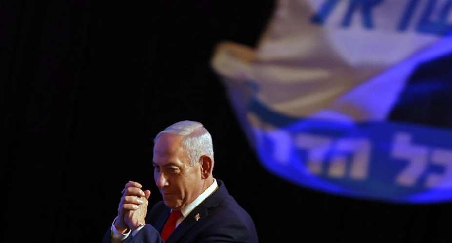 Israels Prime Minister Benjamin Netanyahu gestures to his supporters at the election night rally after the first exit polls were announced, in Jerusalem. -  Jalaa MAREY / AFP