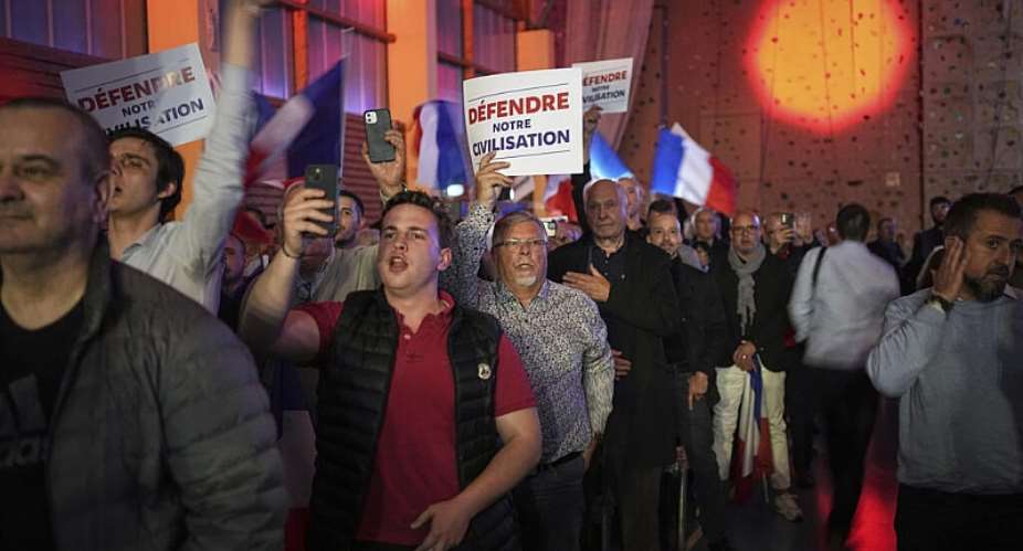 Supporters of the far-right Reconquete party, led by Eric Zemmour, hold up signs reading Defend our civilisation at a party meeting near Lyon, in 2024. - AP - Laurent Cipriani