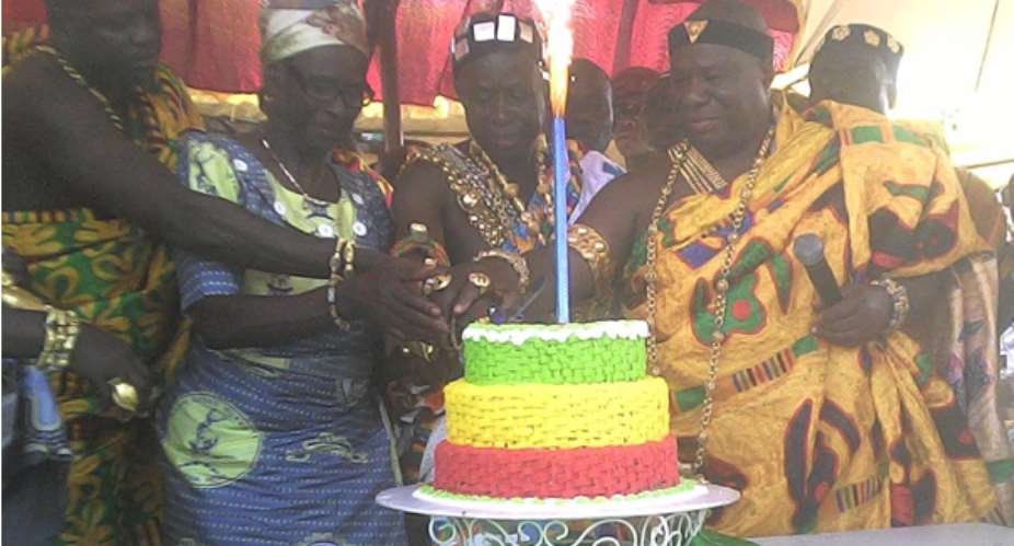Nana Obeng Nuako III, third from left, being assisted to cut the anniversary cake
