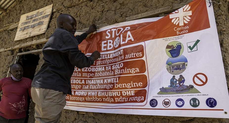 A man hangs an Ebola awareness banner in the Kigonze camp in Bunia, in the eastern Democratic Republic of the Congo, on 28 May 2026. -  GLODY MURHABAZI / AFP