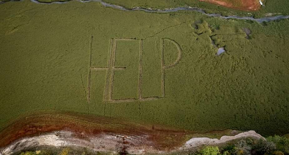 The word HELP has appeared on the dry lake bed. -  Fabrice COFFRINI / AFP