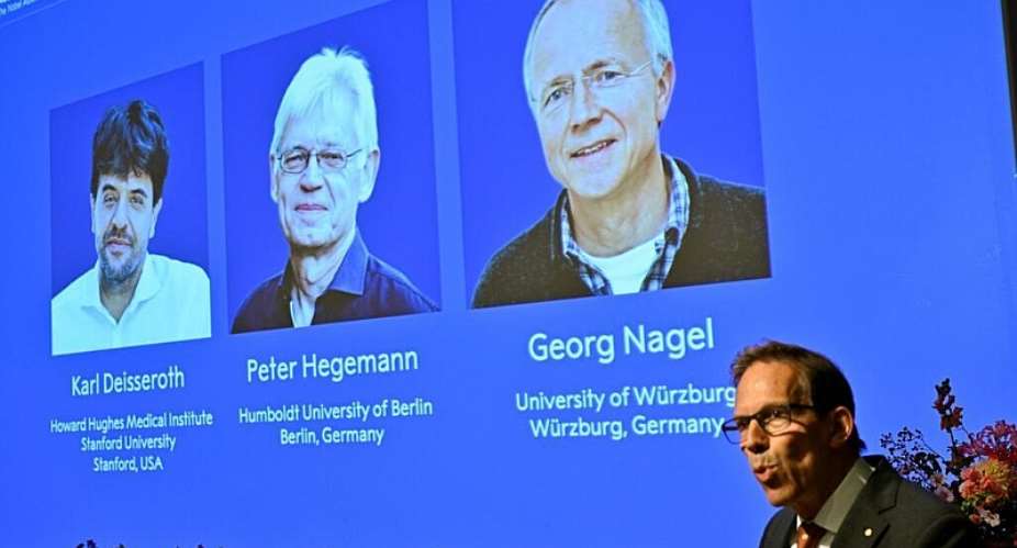 Karl Deisseroth, Peter Hegemann and Georg Nagel are shown on the screen as they are awarded the 2026 Nobel Prize in Physiology or Medicine. -  Pontus Lundahl, TT News Agency via AP