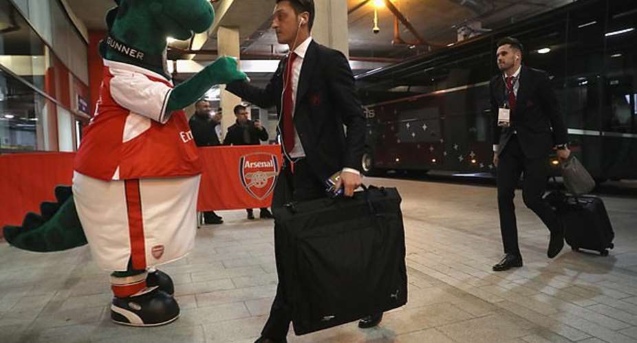 Ozil pictured shaking hands with Gunnersaurus ahead of a match at the Emirates Stadium