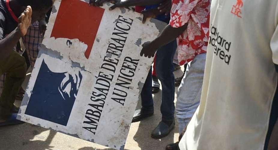 Protesters take down the sign from the French embassy in Niamey on 30 July 2023. Relations between Niger and France have deteriorated sharply since a 2023 coup. -  AFP