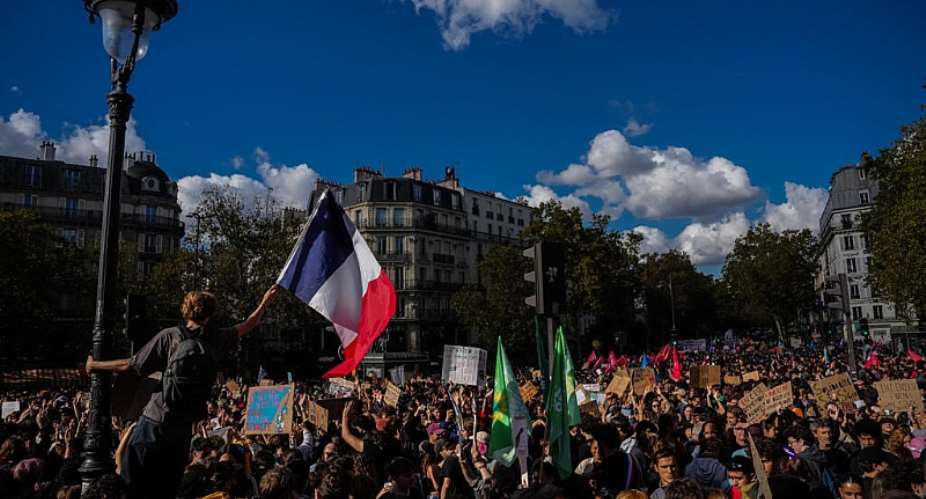 A student in Paris brandishes the French flag during Act IV of a protest movement over poorly resourced schools and staff shortages -  AP Photo/Aurelien Morissard