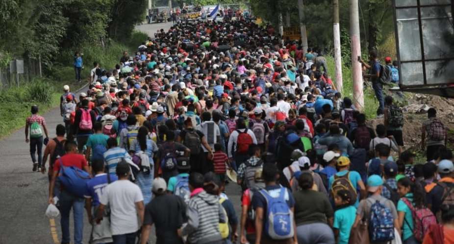 Some 1,500 Honduran immigrants walk north in a migrant caravan on Tuesday near Esquipulas, Guatemala. The caravan, the second of its size in 2018