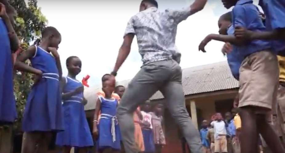 Percy Sackey with his pupils in the school compound, dancing